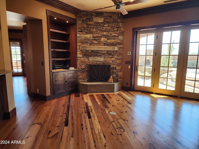 unfurnished living room with a healthy amount of sunlight, wood-type flooring, and built in features