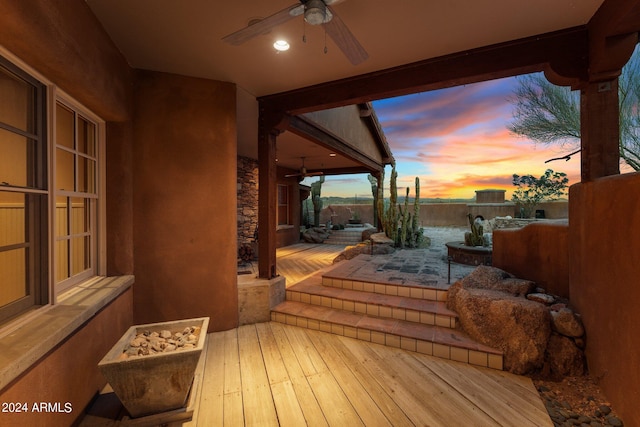 deck at dusk with a patio and ceiling fan