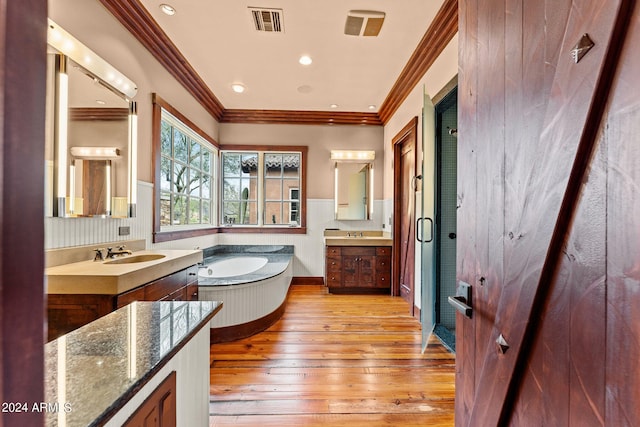 bathroom featuring a tub, crown molding, oversized vanity, and wood-type flooring