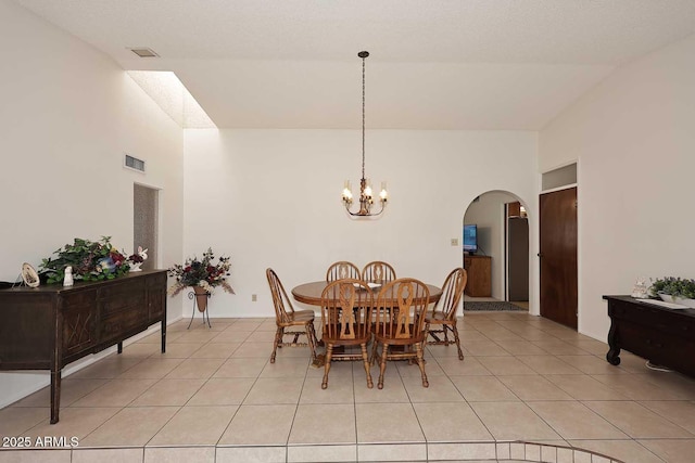 tiled dining area with a notable chandelier and a textured ceiling