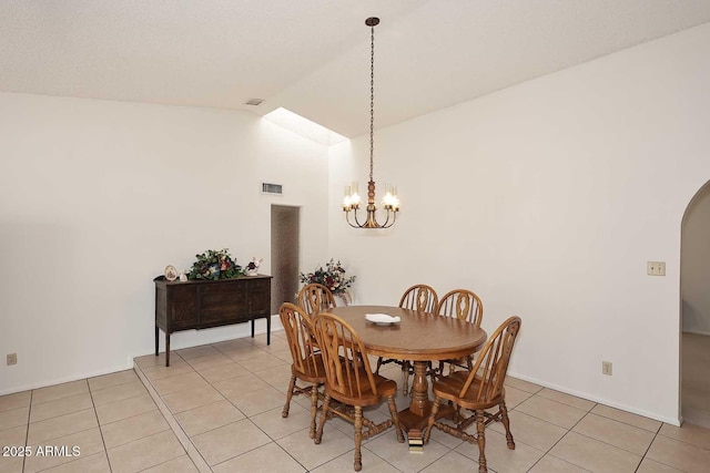 tiled dining room featuring vaulted ceiling, an inviting chandelier, and a textured ceiling