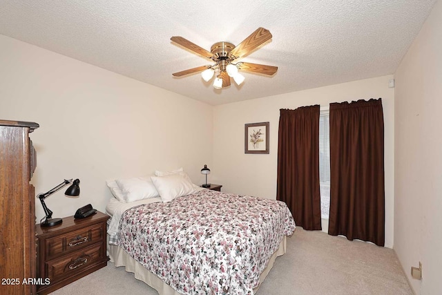 carpeted bedroom with ceiling fan and a textured ceiling