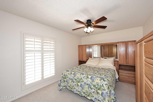 carpeted bedroom with ceiling fan and a textured ceiling