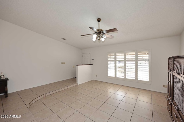 unfurnished living room featuring a textured ceiling, ceiling fan, and light tile patterned floors