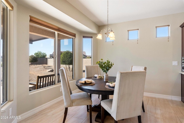 dining room with baseboards, a notable chandelier, and light wood-style flooring