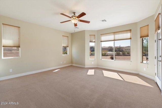 carpeted spare room with ceiling fan