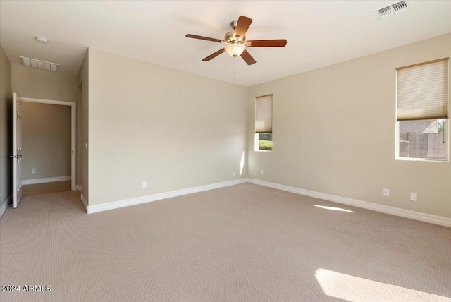 spare room featuring ceiling fan and light colored carpet