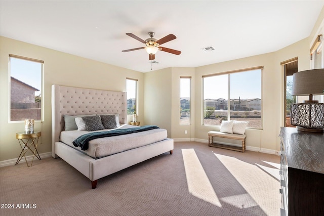 bedroom with baseboards, visible vents, and light carpet