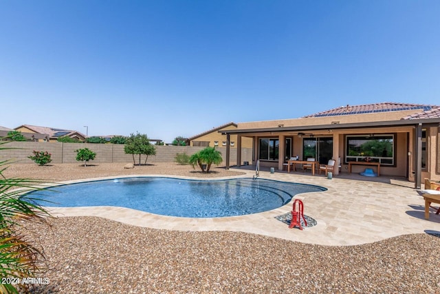 view of swimming pool with ceiling fan and a patio area