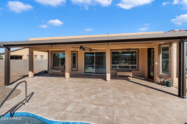 rear view of house featuring a ceiling fan, a patio area, and fence