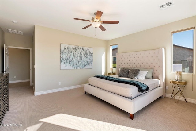 bedroom featuring visible vents, light colored carpet, and baseboards