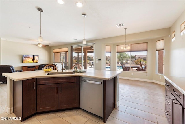 kitchen featuring a wealth of natural light, a center island with sink, and stainless steel dishwasher