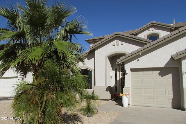 mediterranean / spanish-style home with a garage