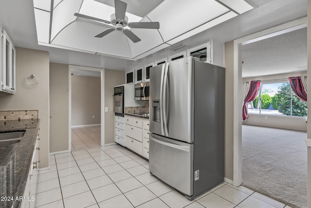 kitchen with light colored carpet, ceiling fan, black appliances, dark stone countertops, and white cabinets