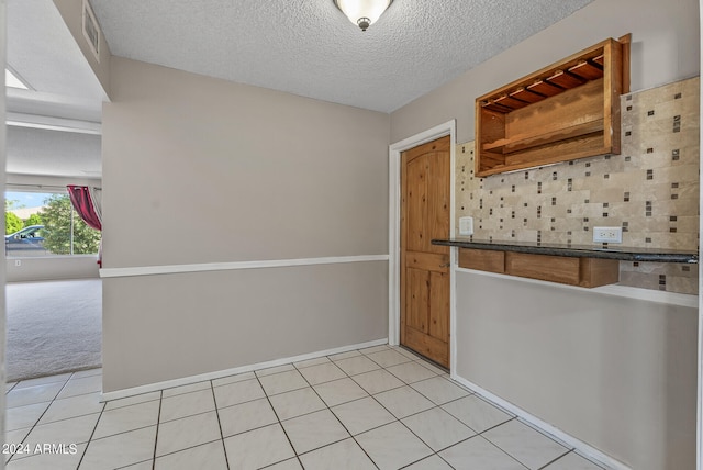 kitchen with light carpet and a textured ceiling