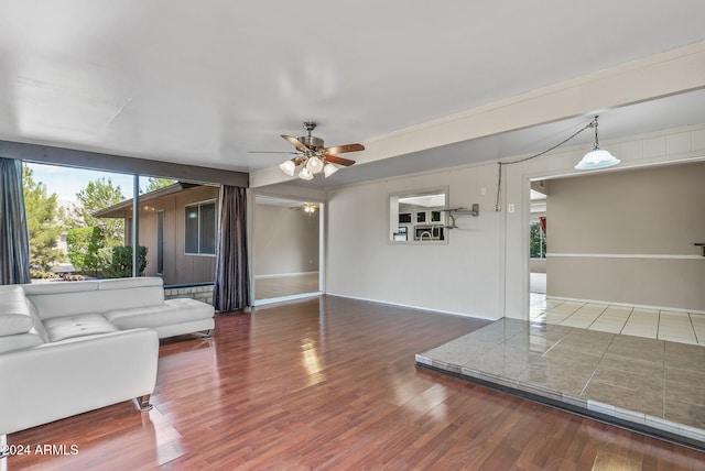 unfurnished living room with ceiling fan and dark hardwood / wood-style flooring