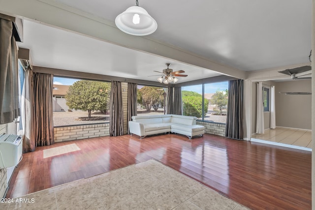 unfurnished living room with hardwood / wood-style floors, ceiling fan, and a wealth of natural light