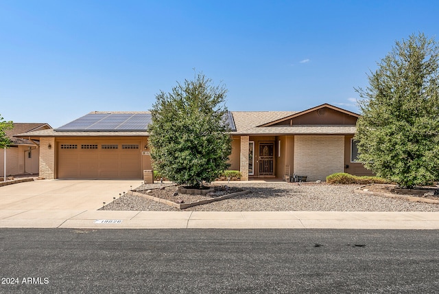 view of front facade featuring solar panels and a garage