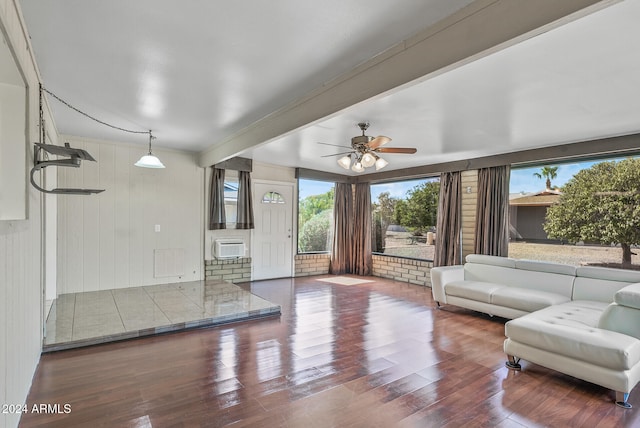 living room featuring hardwood / wood-style floors, ceiling fan, a wall mounted air conditioner, and wooden walls