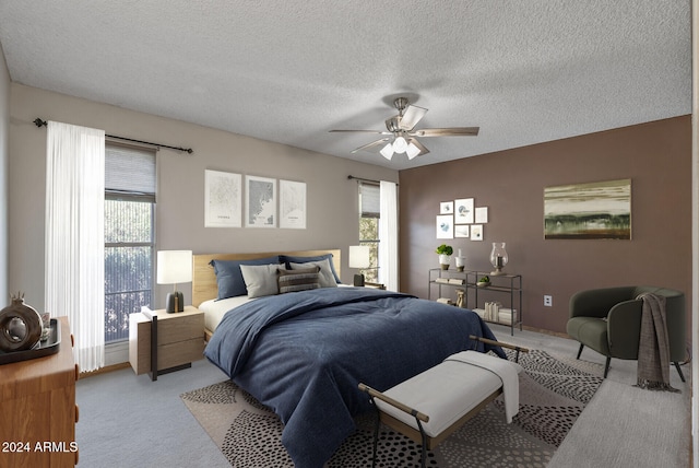 carpeted bedroom with ceiling fan and a textured ceiling