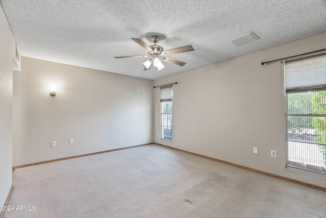 spare room with a textured ceiling, plenty of natural light, and ceiling fan