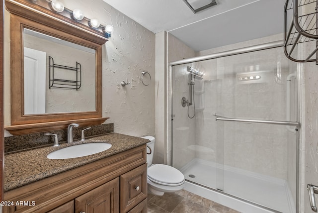 bathroom with vanity, an enclosed shower, and toilet