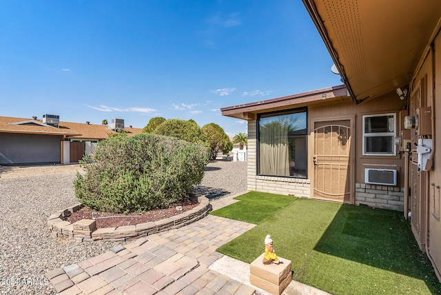 view of yard with a patio, a wall mounted AC, and central AC