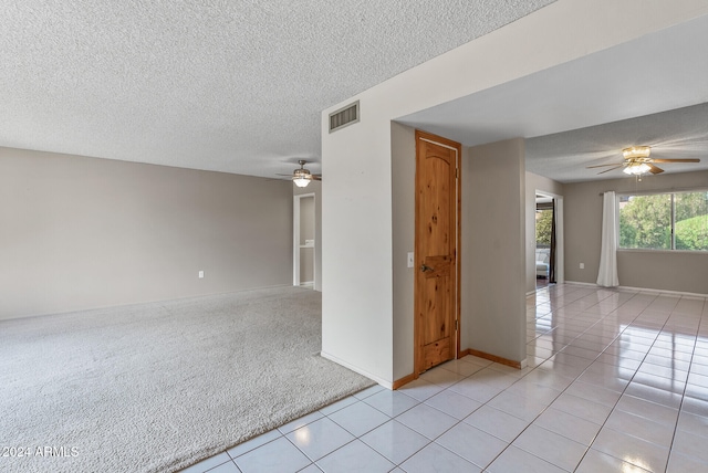 unfurnished room with ceiling fan, light tile patterned flooring, and a textured ceiling