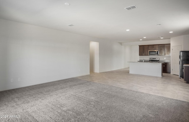 unfurnished living room featuring light colored carpet