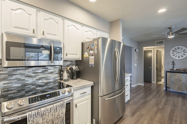 kitchen with dark hardwood / wood-style floors, tasteful backsplash, white cabinets, ceiling fan, and stainless steel appliances