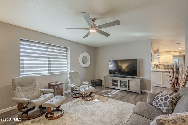 living room featuring ceiling fan and light hardwood / wood-style flooring