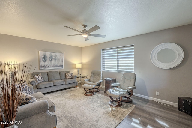 living room featuring a textured ceiling, dark wood-type flooring, and ceiling fan