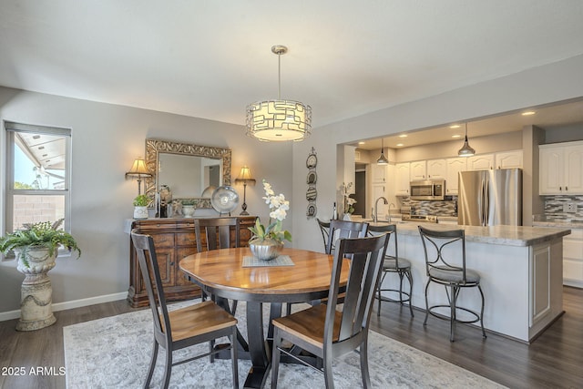 dining space with dark wood-type flooring and sink