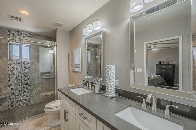 bathroom featuring vanity, walk in shower, and toilet