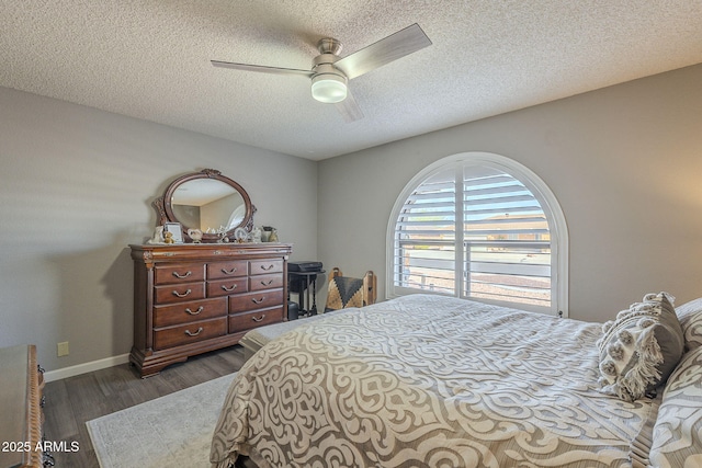 bedroom with ceiling fan, a textured ceiling, and dark hardwood / wood-style flooring