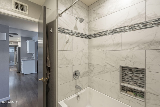 bathroom featuring tiled shower / bath combo and hardwood / wood-style flooring