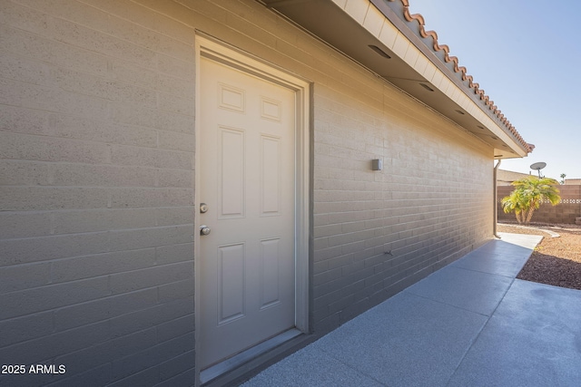 view of exterior entry with a patio