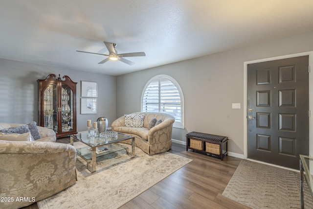 living room with ceiling fan and dark hardwood / wood-style floors