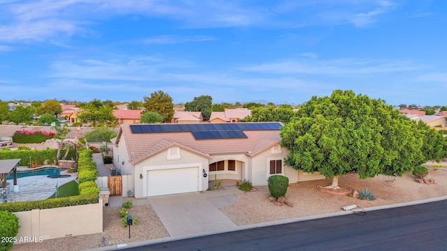 18161 N 63rd Ln, Glendale, AZ 85308 - view of front facade with a tiled roof, fence, an attached garage, concrete driveway, and roof mounted solar panels
