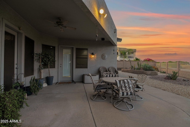 18161 N 63rd Ln, Glendale, AZ 85308 - patio terrace at dusk featuring outdoor dining space, a ceiling fan, and a fenced backyard
