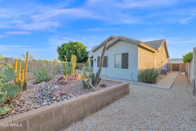 18161 N 63rd Ln, Glendale, AZ 85308 - view of side of property with a patio, cooling unit, a tiled roof, stucco siding, and a fenced backyard
