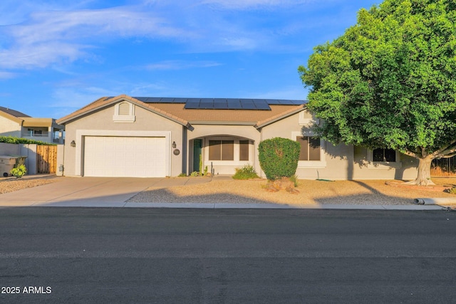 18161 N 63rd Ln, Glendale, AZ 85308 - view of front of home with fence, concrete driveway, a garage, stucco siding, and solar panels