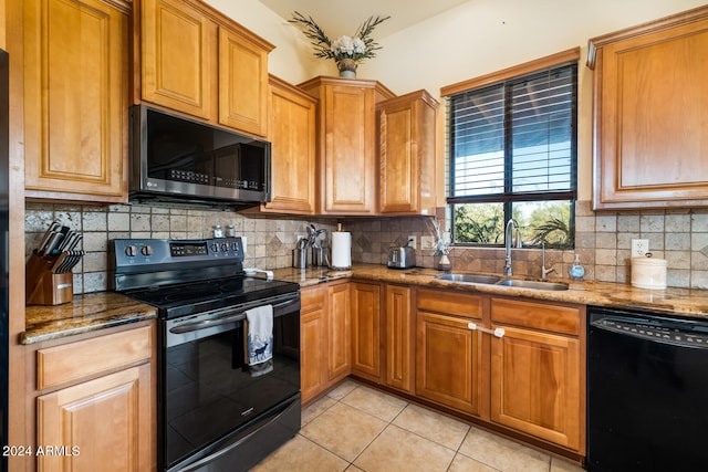 kitchen featuring tasteful backsplash, stone counters, black appliances, and sink