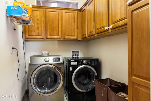 laundry room with washing machine and clothes dryer and cabinets