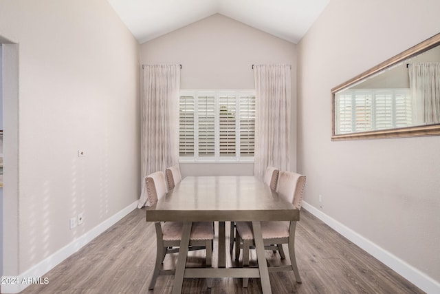 dining space featuring lofted ceiling and light hardwood / wood-style flooring