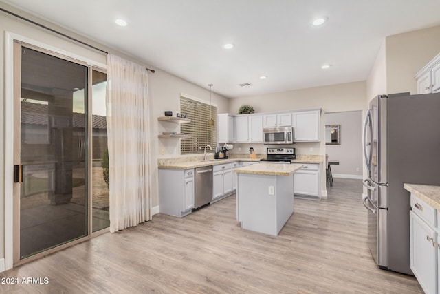 kitchen featuring white cabinetry, light hardwood / wood-style flooring, a kitchen island, and stainless steel appliances