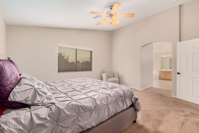 bedroom featuring carpet flooring, ensuite bath, vaulted ceiling, and ceiling fan