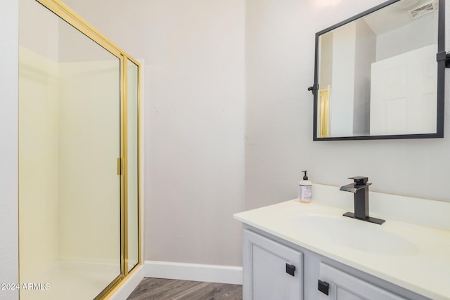 bathroom with hardwood / wood-style floors, vanity, and a shower with door