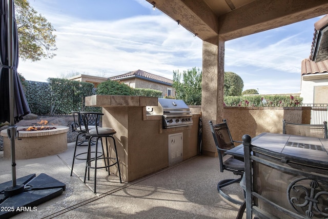 view of patio with grilling area, exterior kitchen, and an outdoor fire pit