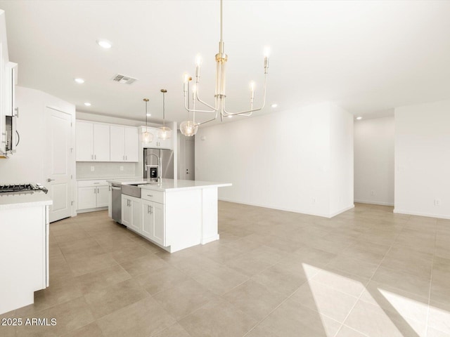 kitchen with decorative light fixtures, white cabinetry, a chandelier, stainless steel appliances, and a center island with sink